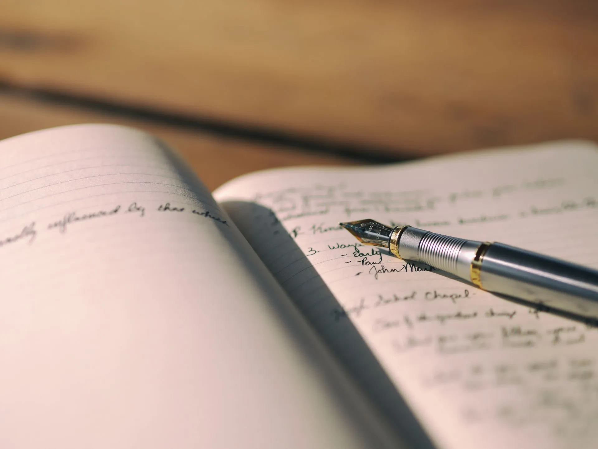 A fountain pen resting on a handwritten journal
